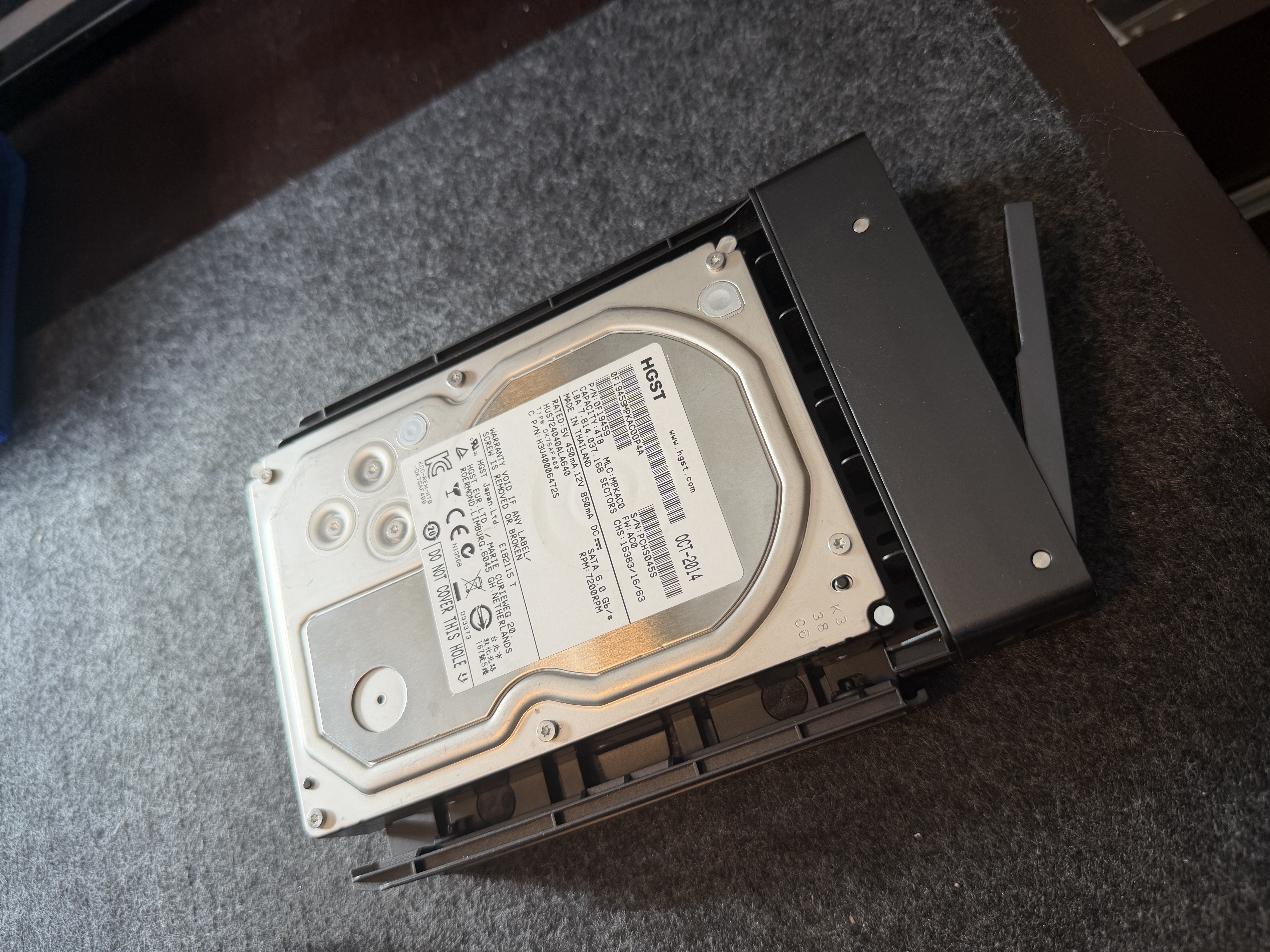 UGREEN DXP6800 Pro drive tray with HGST 4TB drive installed, clamp arm open